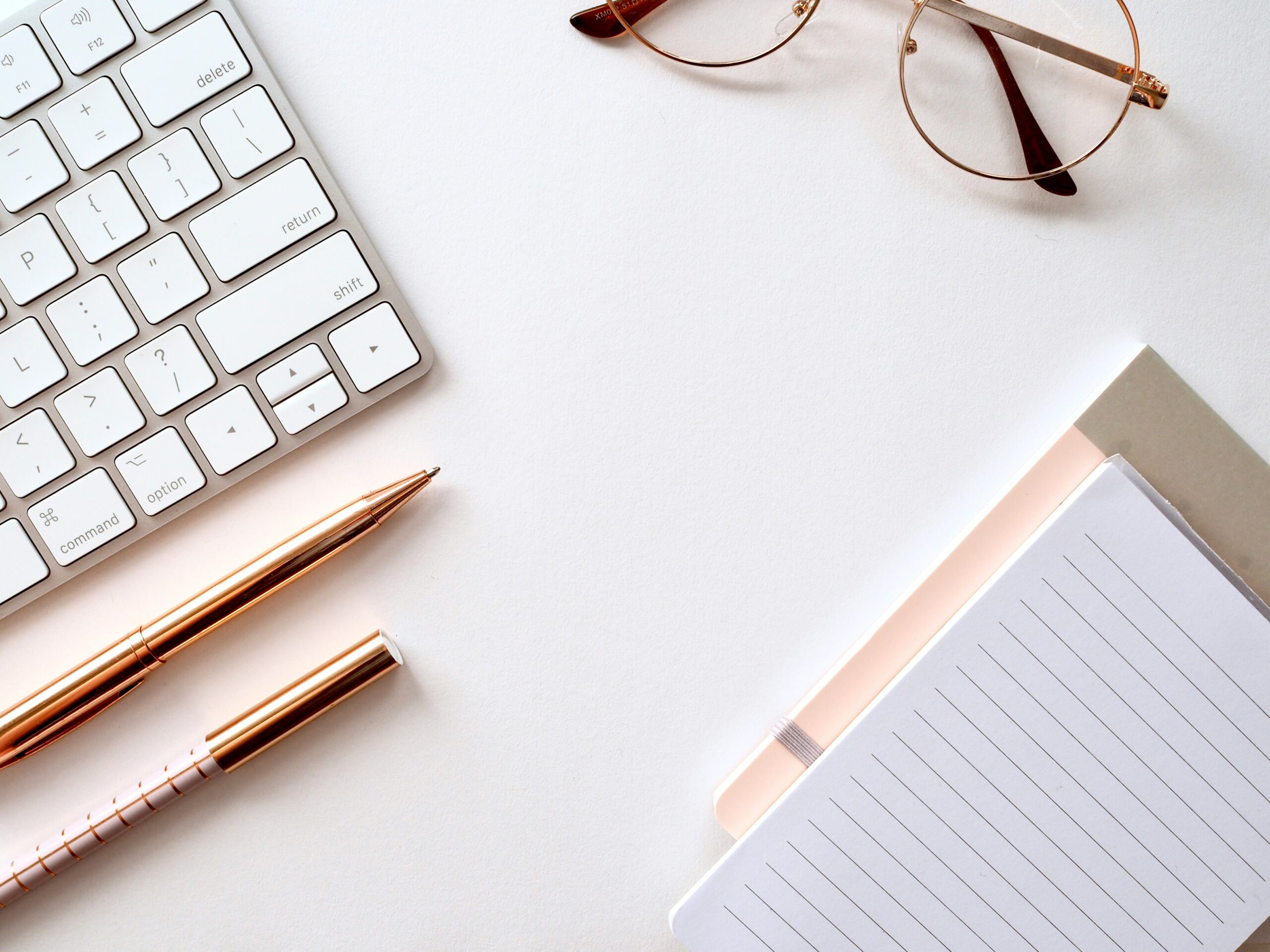 Escritorio con ordenador, libros y gafas